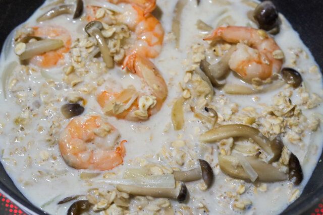 えびの色が変わったら、オートミール、牛乳、顆粒コンソメ、ナツメグ、塩を加える。