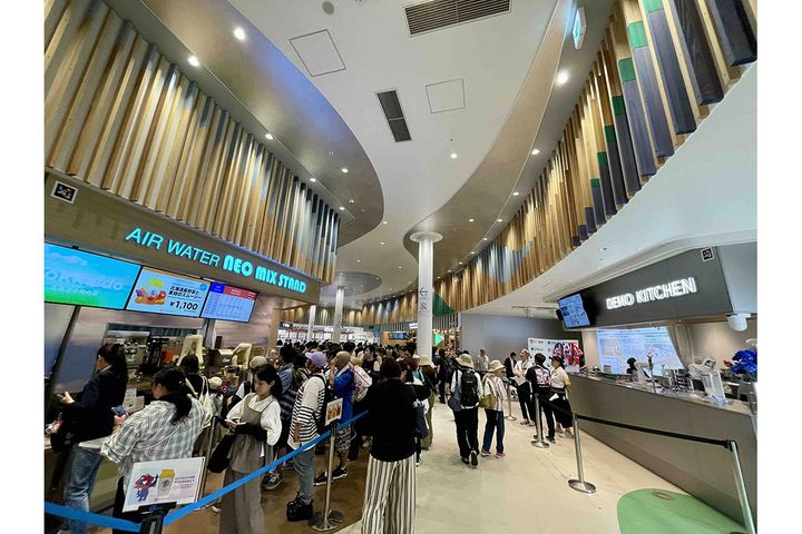 デモキッチン（右）の向かい側に、自動調理ロボットがドリンクを作る実証店舗（左）も。