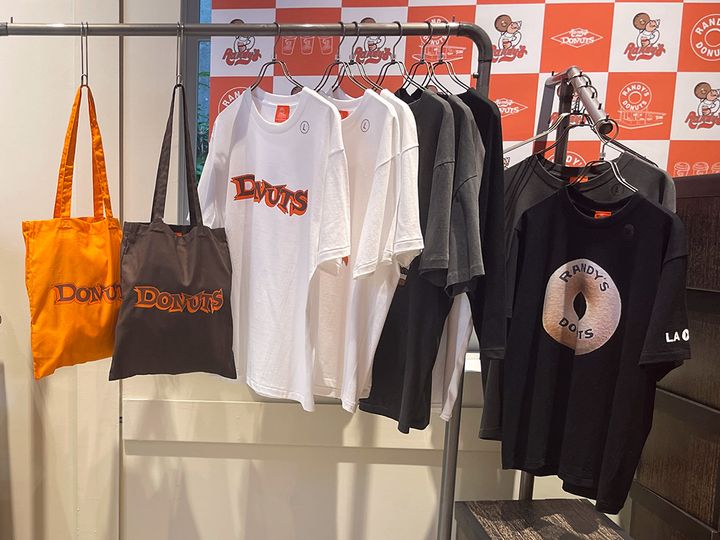 （左から）「トートバッグ オレンジ／ブラック」各3300円、「Tシャツ ホワイト／グレー／ブラック」Mサイズ、Lサイズ、XLサイズ各5500円、「東京1号店限定Tシャツ」Mサイズ、Lサイズ、XLサイズ各5500円 ※数量限定発売