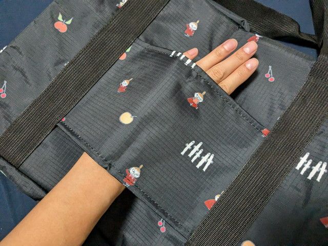 MOOMINボストンバッグの大きな外ポケットに手を入れた様子