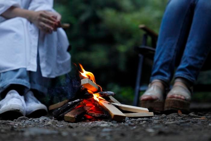 直火で焚き火をする2人