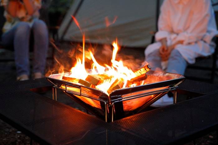 焚き火台で焚き火をする2人