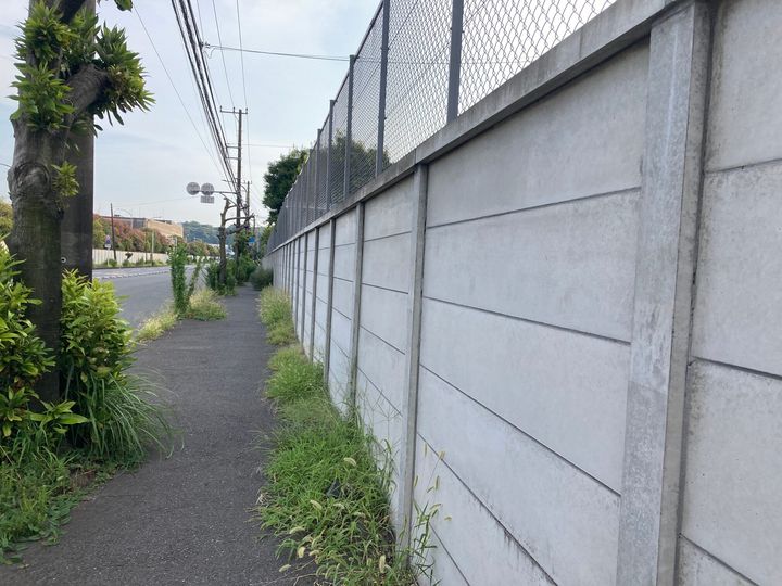 工場の外は長い塀が続く