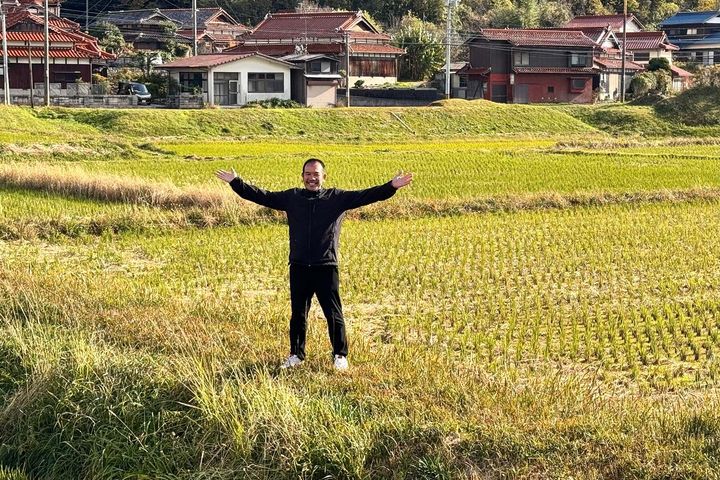自営田で手を広げて立つ永山さん