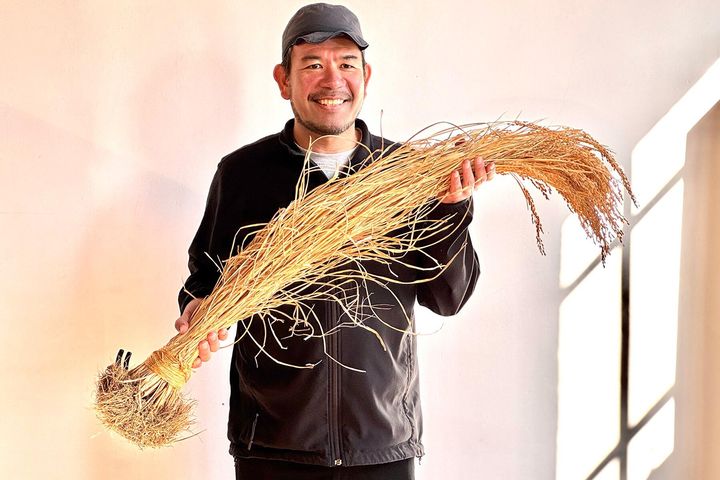 稲穂を誇らしげに持つ永山さん