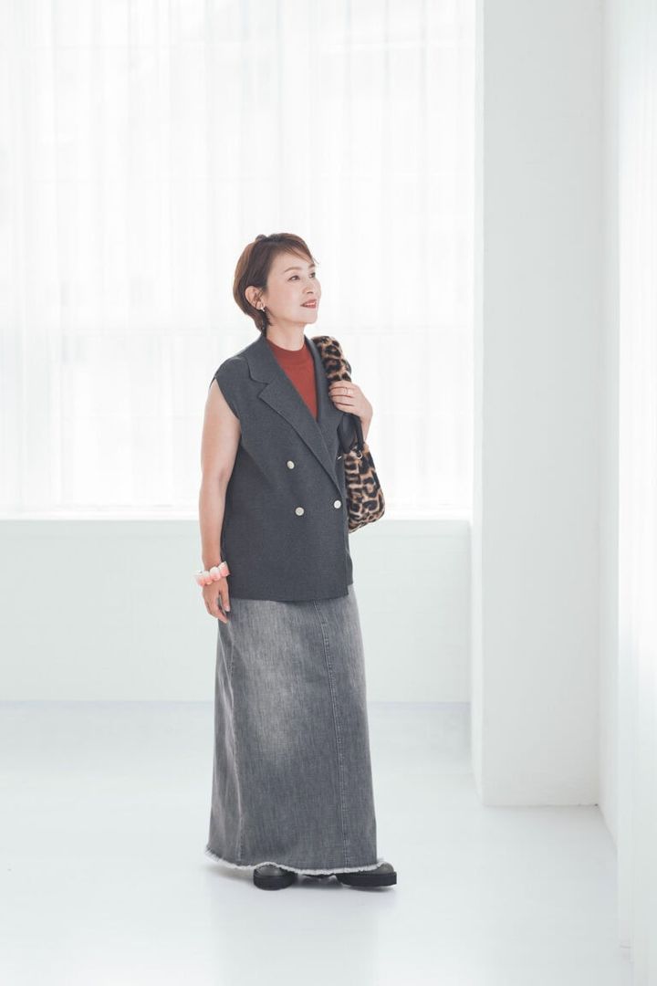 デニムスカート¥13,000、ニットジレ ¥9,990、ニット¥8,990／すべてプラステ、バッグ¥22,000／ノマディス（ノーベルバ）、 ブーツ¥44,000／銀座かねまつ（銀座かねまつ6丁目本店）、イヤリング¥11,000、ブレスレット¥21,600／ともにアビステ、リング¥11,000／ワンエーアールバイウノアエレ（ウノアエレ ジャパン）