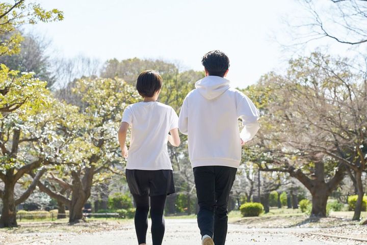 屋外で並んで走る男女