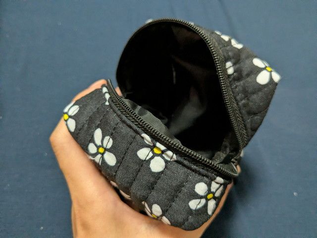 黒い小ポーチの開口部と内側の様子（持ち歩きに便利）