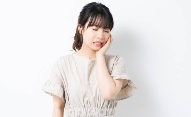 歯の痛みに耐える女性のイメージ