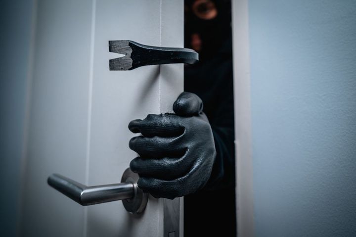 黒川の手袋をはめ、バールのようなものでドアをこじ開けている犯罪者
