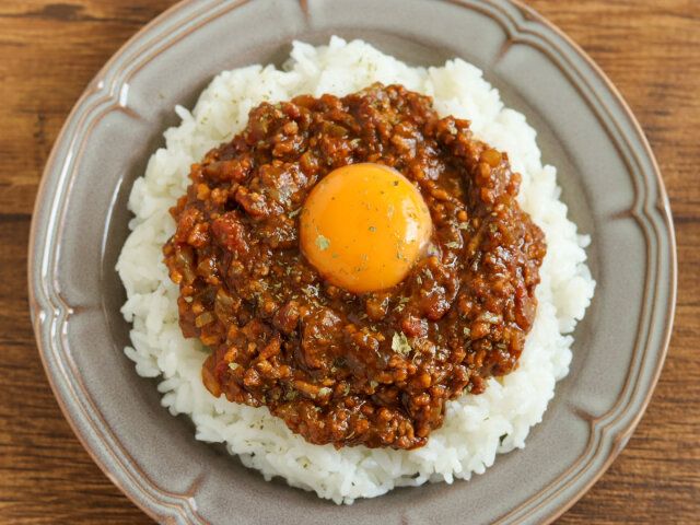 温かいごはんを器に盛り、無水キーマカレーをのせ、真ん中に卵黄をトッピングし、ドライパセリをかける。