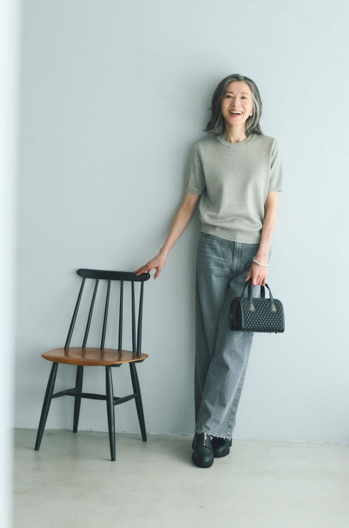 デニムパンツ¥28,600／アッパーハイツ（ゲストリスト）、ニット¥25,300／エブール（リトルリーグ インク）、バッグ¥253,000／ティッサ・フォンタネダ（アッシュ・ペー・フランス）、イヤリング¥5,670／アビステ、ブレスレット¥7,700／ピルグリム（ズットホリック）靴¥27,500／ヒミコ