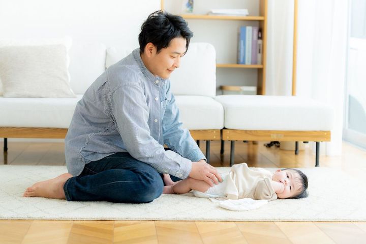赤ちゃんのおむつを交換するお父さん