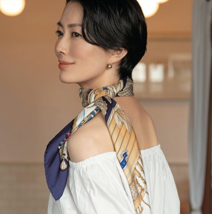 大判スカーフを長めに垂らし、肌の露出バランスを調整したのがポイント。テラス席なら風に揺れてさらに映える。