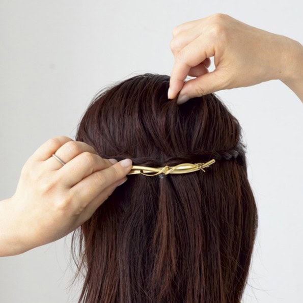 【HOW TO】２．ゴムを隠すようにバレッタを付けたら、写真のようにバレッタの上にある毛束を所々つまんでふんわり感をプラスします。この1ステップでサイドシルエットが美しく整います。