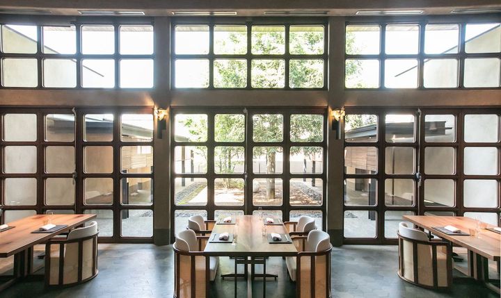 端正に手入れされた中庭を望む、クラシックモダンなダイニングルーム。