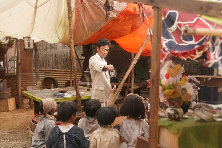 映画『宝島』より人探しをするグスク（妻夫木聡）