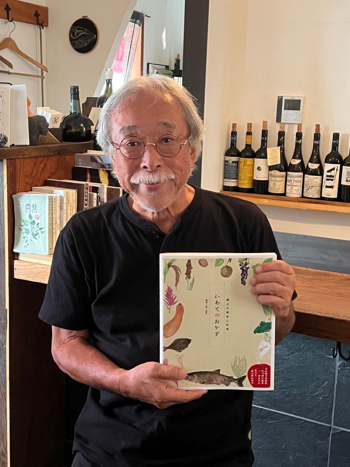 最新刊『いわてのおかず』を手にする服部一景さん