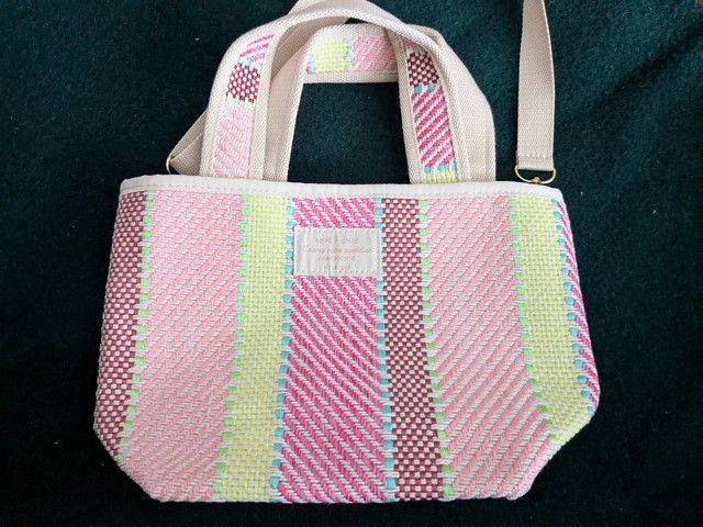 淡いピンク系ストライプと生成りの持ち手が上品なトート全体