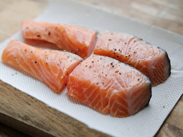 生サーモンは、キッチンペーパーで水分をふき取り、半分に切ったら両面に塩こしょうを振って下味を付ける。