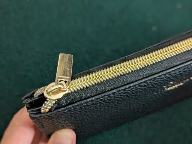 ゴールドのメタルファスナーと引き手ディテール