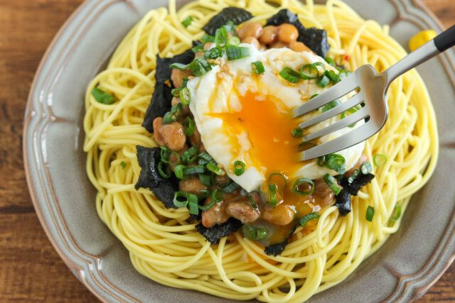 フォークでポーチドエッグを崩す。