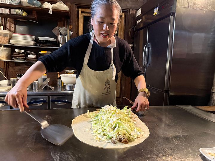 大きなコテを生地下に差し込み、気合いが入る福島彰子さん