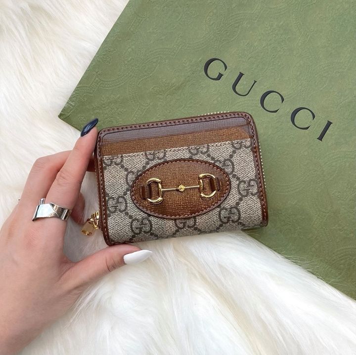 グッチのコインケースを持つ女性の手元