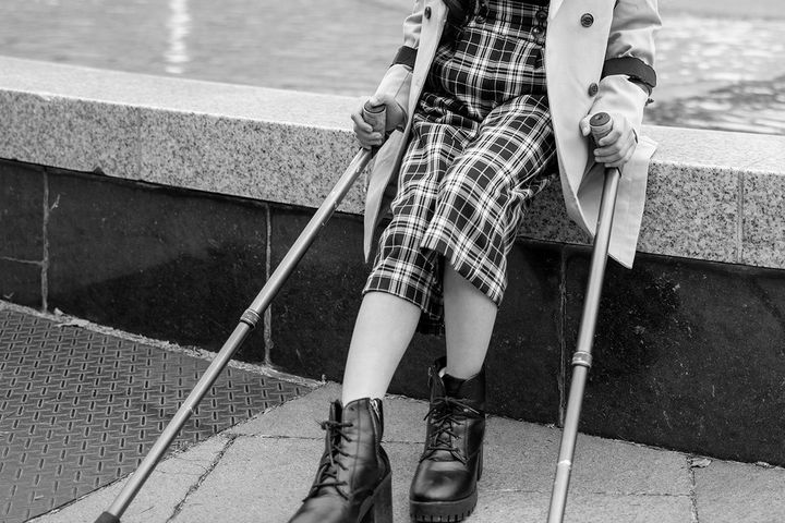 松葉杖を持って座っている少女