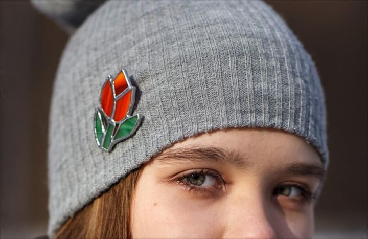 ニット帽に花のブローチがついている