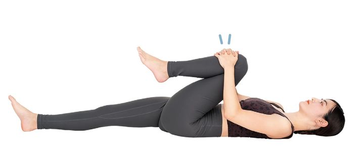 仰向けになり、左膝を曲げ、両手で抱える。