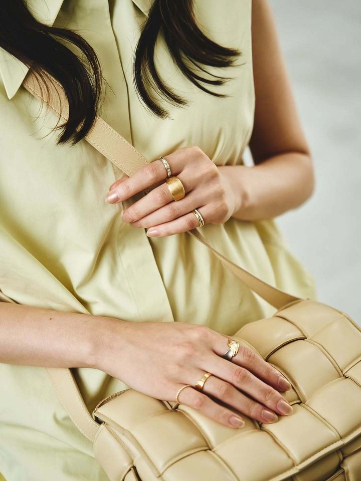 指にたくさんのリングを着けた女性