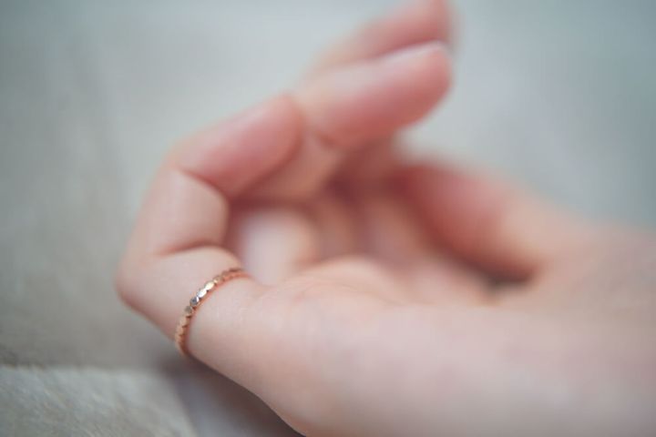 ピンキーリングを着けた女性の手