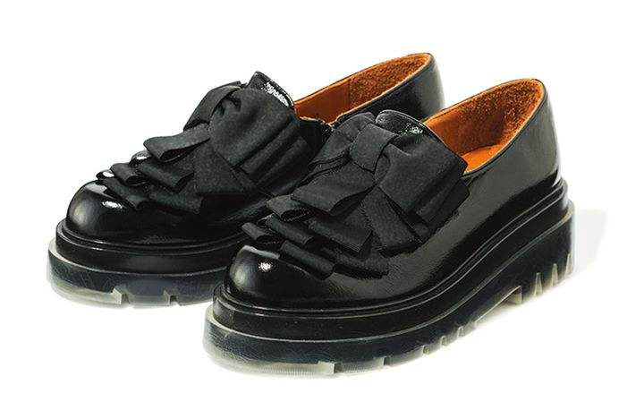 リボンディテールが目を惹く、艶やかなブラックレザーのローファー。厚底ソールがタフな印象ながら、可憐さも漂う秀逸デザイン。