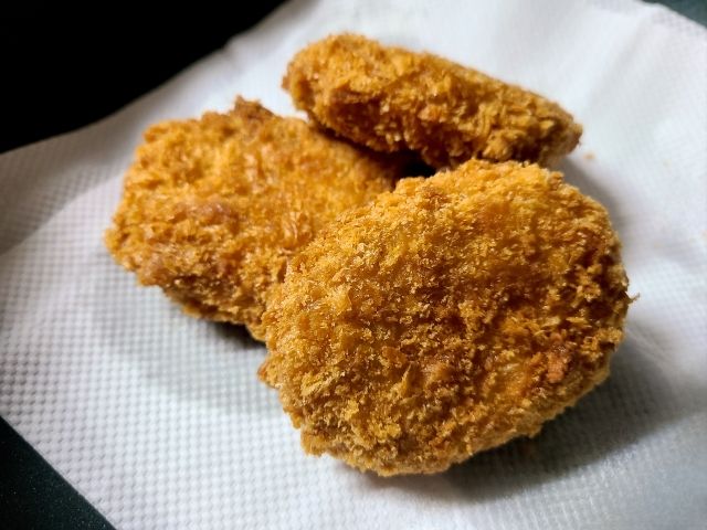 キッチンペーパーの上のコロッケ3つ