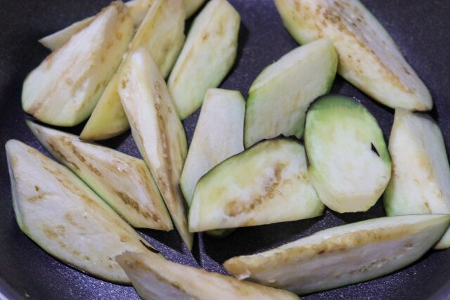 フライパンにサラダ油を熱し、なすを入れたらすぐにフライパンをゆすって全体に油をからめる。
