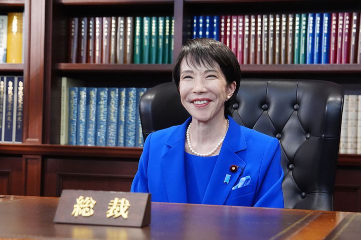 自民党総裁室の椅子に座り、笑顔を見せる高市早苗新総裁（2025年10月、時事）