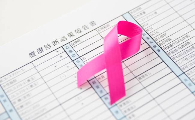 ピンクリボンと健康診断表のイメージ