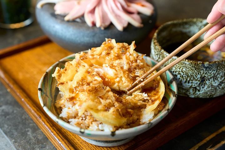 「卵天ぷら飯」を食べる様子