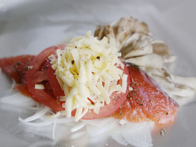 ①を置いたら、トマトを広げて乗せ、その上にピザ用チーズを置き、黒こしょうをかける。