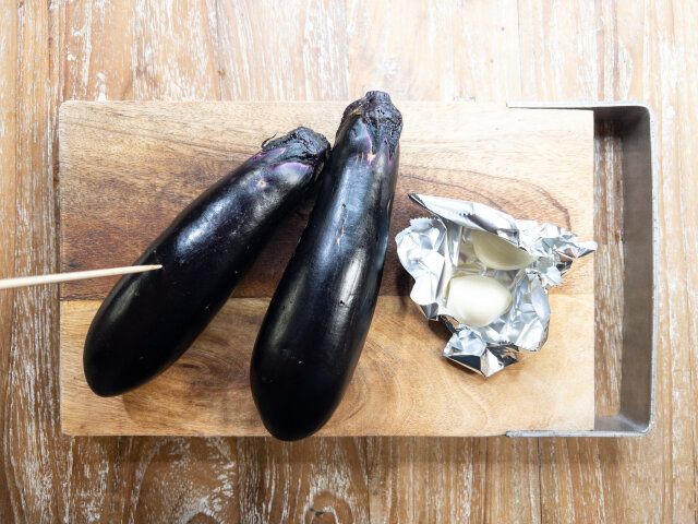 なすの皮に竹串を刺して穴を数カ所開け、にんにくはアルミホイルで包む。