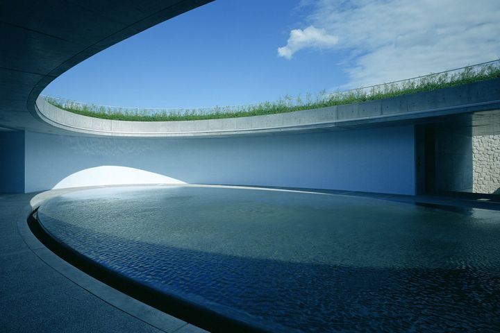 「ベネッセハウス オーバル」の中庭。静かな水面が青い空や周囲の自然を映し出す。