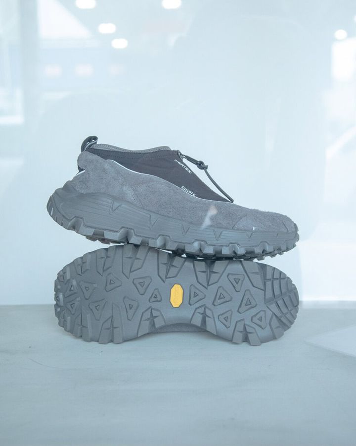 「AKK-ZIP」モデルをベースにF/CE.別注仕様で構築。ライニングは防水透湿機能を備えたSUICOKE SHERPA、アウトソールには濡れた路面でも乾いた路面でも高いグリップ力を発揮する『Vibram MEGAGRIP』配合のソール、ミッドソールには軽量で衝撃吸収に優れたSLE配合の高スペックなソールを採用。