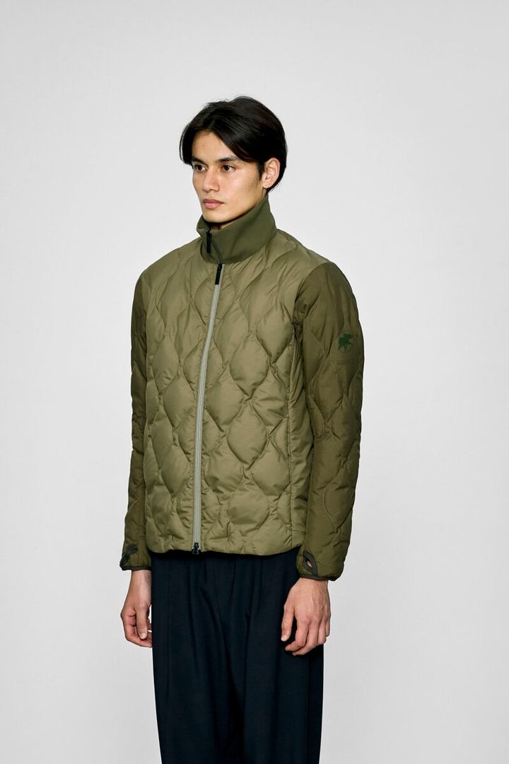 ポリエステル 100%のパウダータッチの⾼密度織物を採⽤した1枚。サラッとした質感でシワになりづらく、防⾵性に加え、はっ⽔性も備えている。