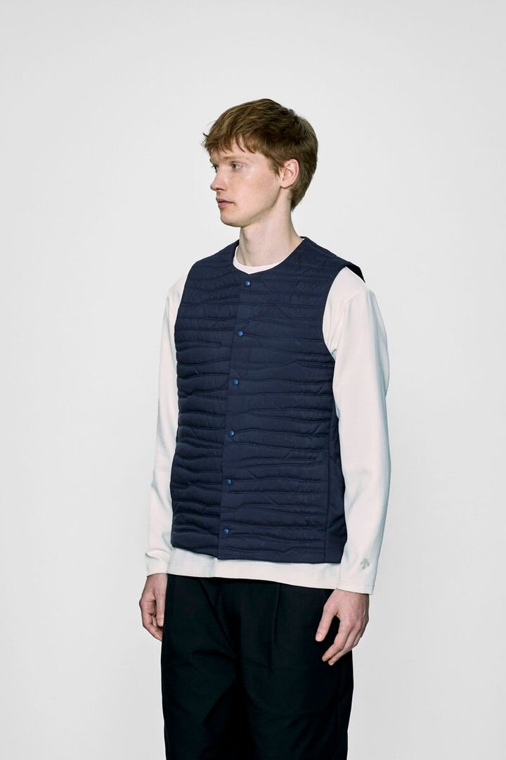 表地にはポリエステル 100%のパウダータッチの⾼密度織物を採⽤。サラッとした質感でシワになりづらく、防⾵性に加え、はっ⽔性も備えている。ゼブラ柄のオリジナルエンブロイダリーキルティングが、さりげなく個性を発揮する。