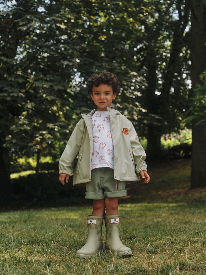 レインウェアには、ベージュのレインコートとローレルグリーンのレインクロークを展開。いずれもブランドロゴ入りのスナップボタンと、コラボ限定のシェブロンプリントのライニングが特徴だ。