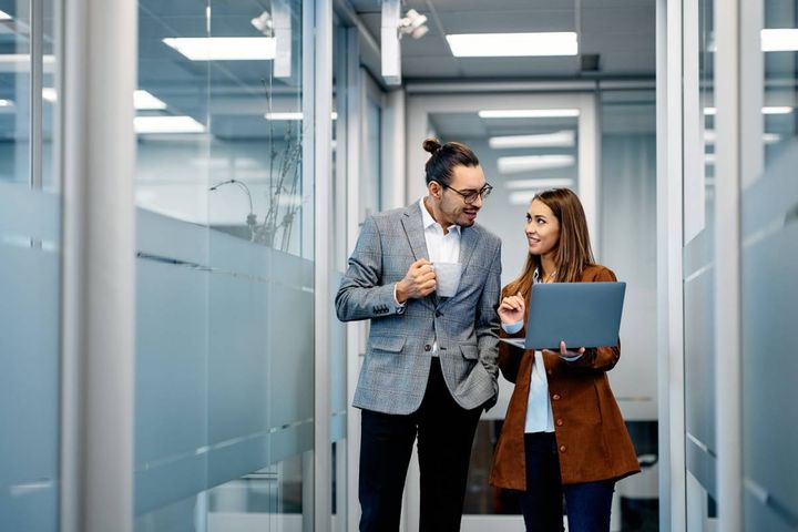 オフィスの廊下を歩きながら話す男女