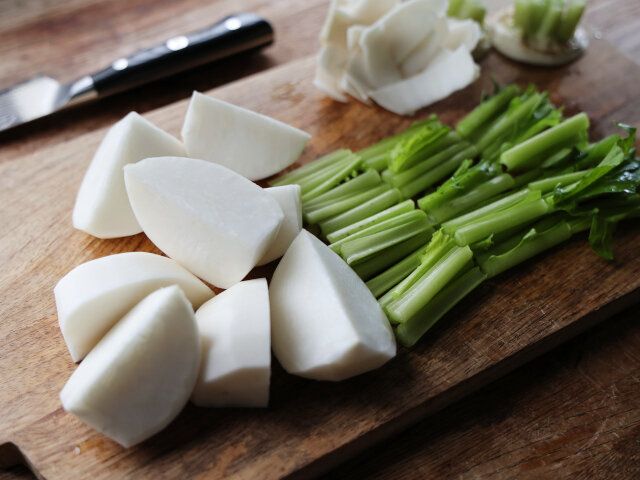 かぶは、実と茎の付け根の部分を切り落とし、実を4等分に切って皮をむき、葉と茎は3～4cmの長さに切る。