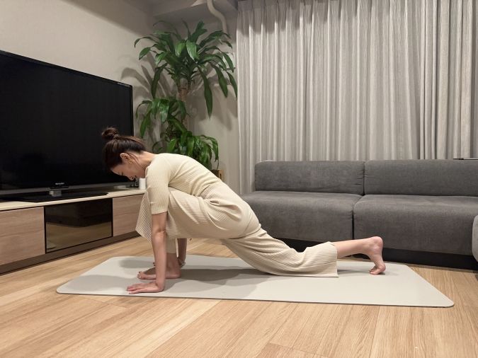 四つ這いの体勢から、片脚を手と手の間に出してランジの姿勢になる。