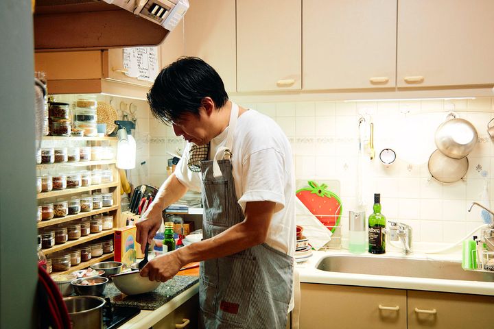 自宅のキッチンで調理する佐藤さん